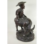 An Oriental carved hardwood figure of a man seated on a buffalo, 23" high