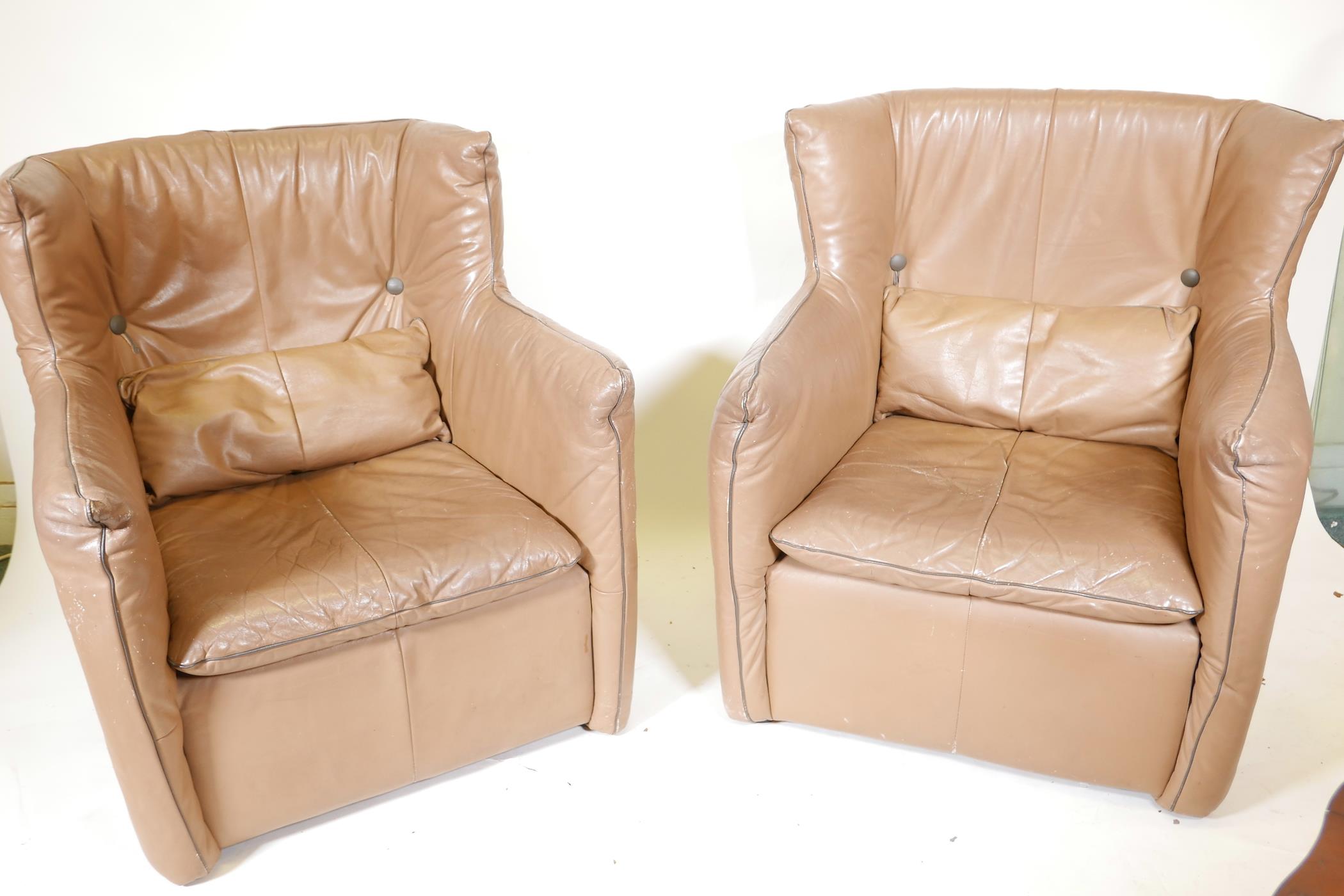 A pair of retro 1970s leather wing back armchairs, 36" high