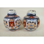 A pair of pottery lamp bases in the form of lidded ginger jars decorated in the Imari palette, 8¼"