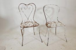 A near pair of vintage, painted wrought iron garden chairs