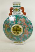 A Chinese porcelain pilgrim flask decorated with fiery dragons on a green ground around a symbolic