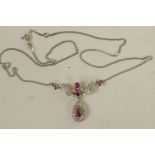 A 9ct white gold, diamond and ruby pendant on a 9ct gold chain (5.6 grams)