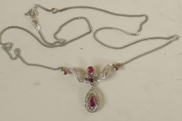 A 9ct white gold, diamond and ruby pendant on a 9ct gold chain (5.6 grams)