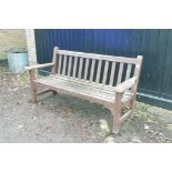 A weathered teak garden bench, 64" wide