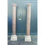 Architectural salvage: A pair of Indian teak columns with carved capitals, mounted on carved stone