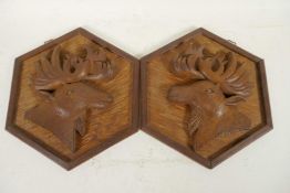 A pair of carved wood wall plaques of stag heads on hexagonal frames, 8"
