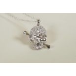 A silver and cubic zirconium encrusted skull pendant necklace, 1" drop