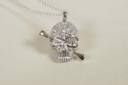 A silver and cubic zirconium encrusted skull pendant necklace, 1" drop