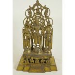 A Chinese gilt bronze figure of three deities standing before a pierced screen decorated with