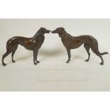 A pair of well cast bronze figures of hounds, 6½" high, 10" long