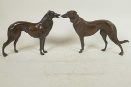 A pair of well cast bronze figures of hounds, 6½" high, 10" long