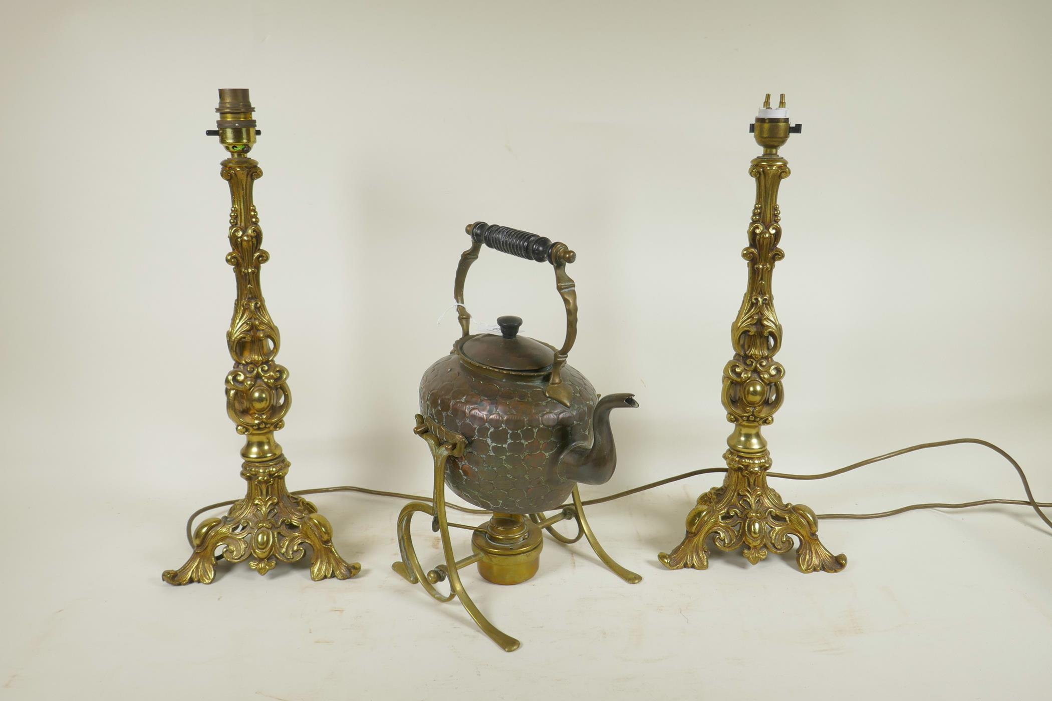 A pair of bronzed metal lamps on triform bases with gadrooned and swag moulded decoration,