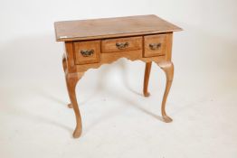 A Continental elm low boy with crossbanded top over three frieze drawers on cabriole legs, the