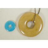 A Chinese turquoise pi-disc pendant, and another larger composition pi disc, largest 2½" diameter