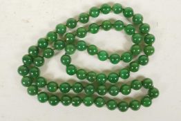 A string of dark green jade beads, 32" long