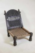 An antique Indian hardwood Pidha chair, with carved and pierced decoration to back, woven seat and