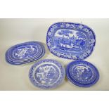 A C19th blue and white meat plate with a boatman on a river, within a wild rose border, possibly