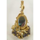 A gilt bronze table mirror in the form of a lute with cherubs, on a marble base, 12" high