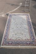 A cream ground Kashmir rug with a traditional tree of life design and a blue border, 62" x 92"