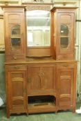 A Dutch Art Nouveau oak mirror back sideboard in two sections, with carved pear tree decoration