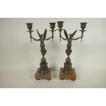 A pair of bronze two branch candelabra, the torch pattern sconces supported by angels, 13" high