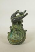 A Chinese filled bronze figure of Buddha seated beneath a meditative hand, seal mark to base, 7½"