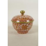 A Chinese red and white porcelain rice bowl and cover with floral decoration highlighted with