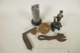A collection of curios, a Boy Scouts knife, a miniature microscope, a Bully Beef tin opener, an