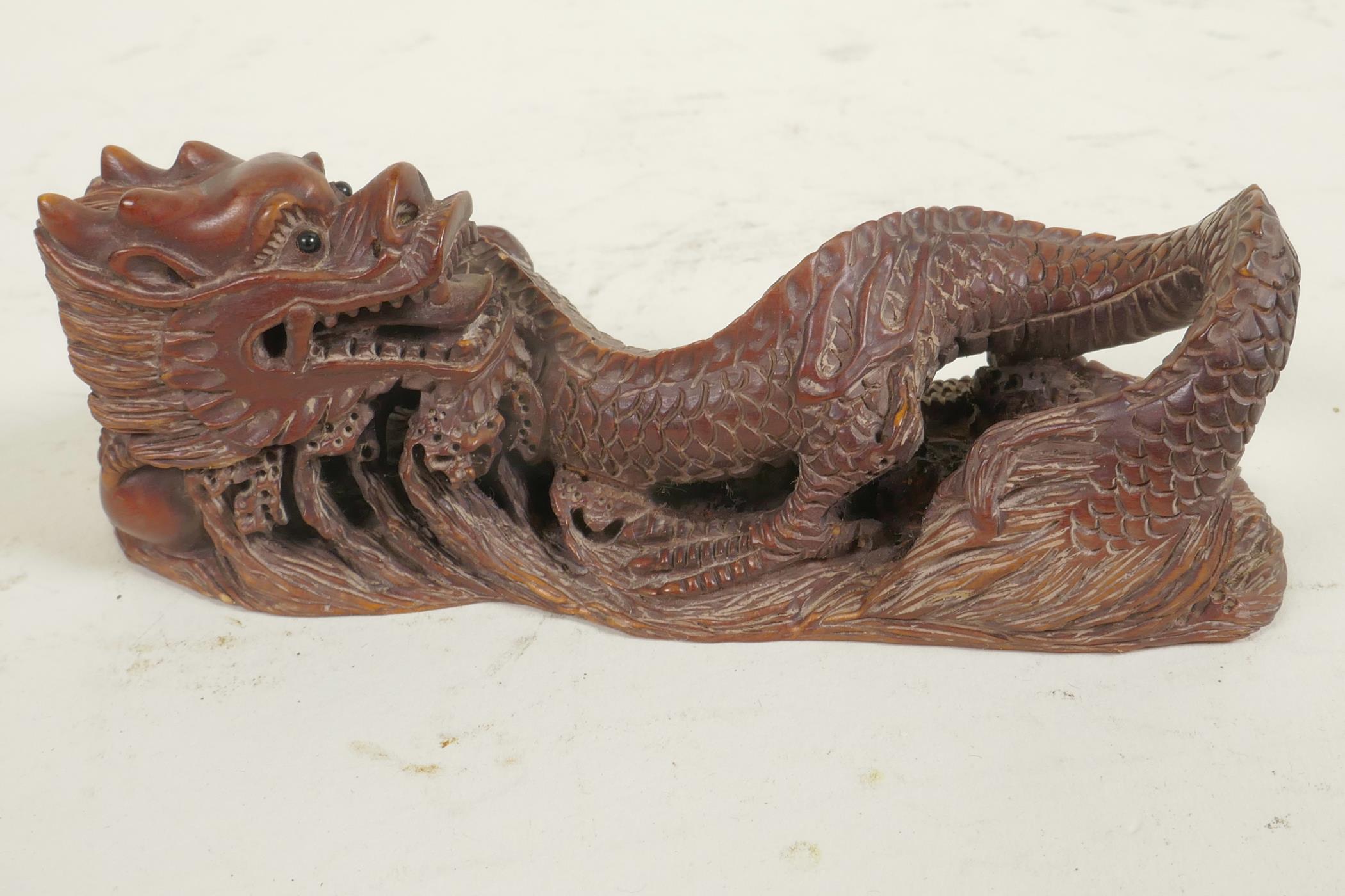 A Japanese carved hardwood okimono of a dragon, 4½" long