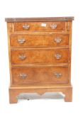 A walnut Reprodux bachelor's chest with four long drawers, raised on bracket feet, 23½" x 14",