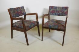 A pair of mid century teak open armchairs, possibly American