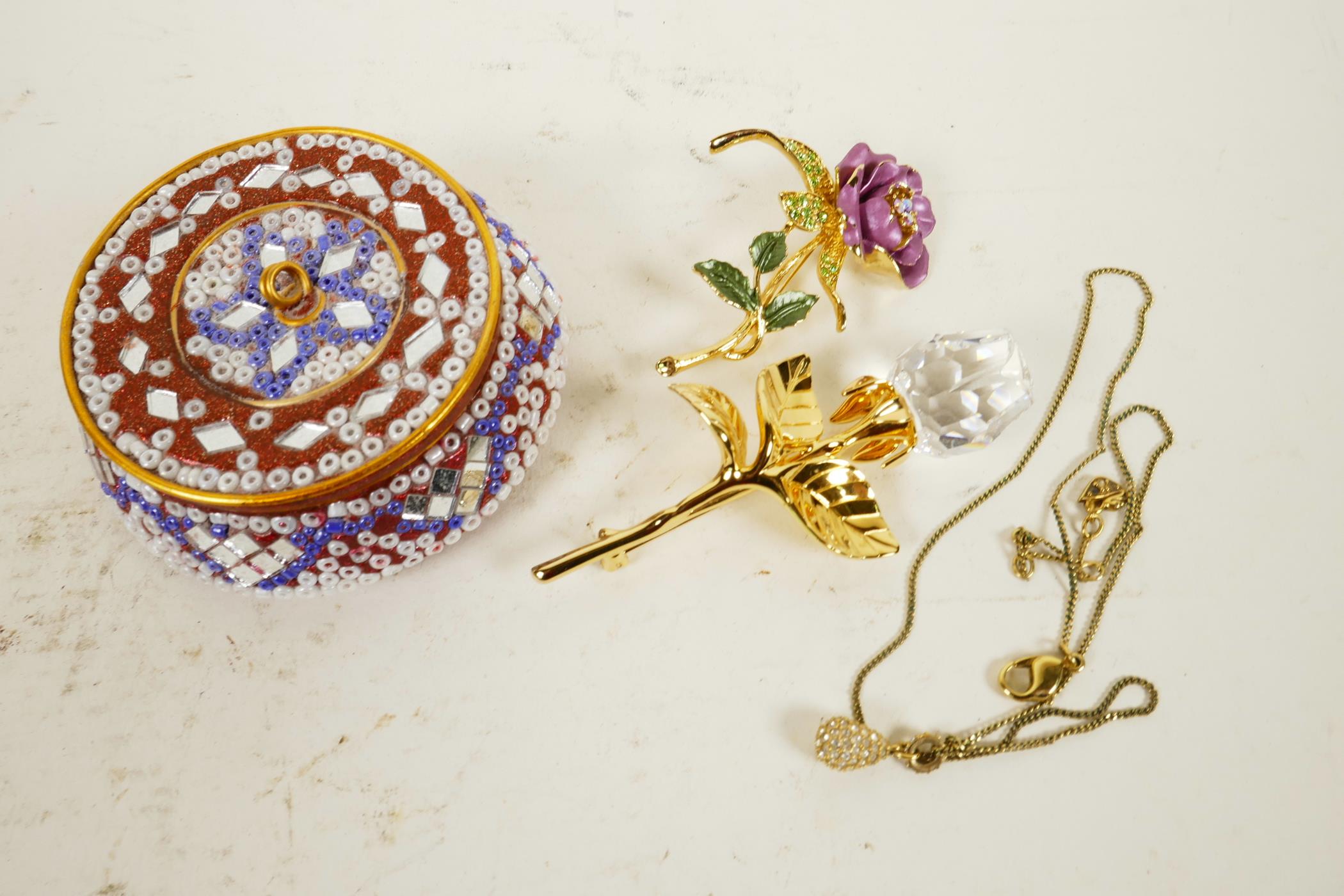 Two Swarovski 'Rose' crystal and gilt flower brooches, a Swarovski pendant, and a micro-mosaic