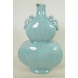 A Chinese pale blue glazed porcelain double gourd vase with embossed decoration of dragons and fish,