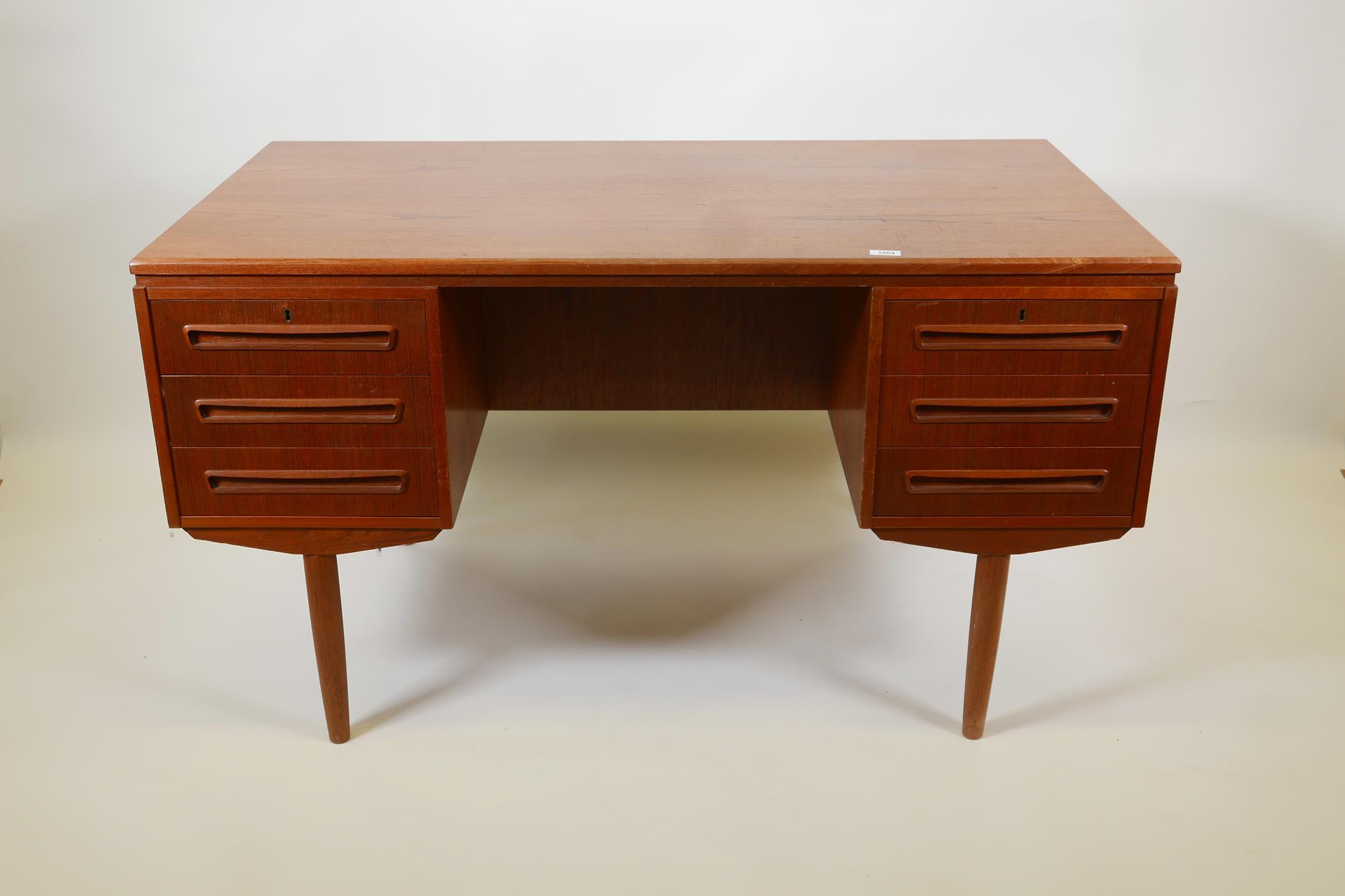 A Danish 1960s teak two sided desk designed by J. Svenstrup for A.P. Møbler, with six drawers to one