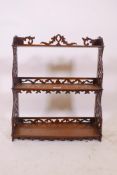 A C19th walnut hanging shelf, with bowfronted shelves and fretwork sides, losses, 18" x 7" x 20"