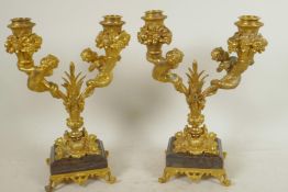 A pair of ormolu two branch table candelabra, the sconces surrounded by bowls of fruit, and the