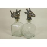 A pair of square section glass decanters with animal head stoppers, 10" high