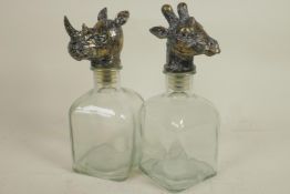 A pair of square section glass decanters with animal head stoppers, 10" high