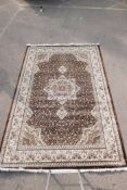 A Turkish brown ground thick pile carpet decorated with a floral medallion design and cream borders,