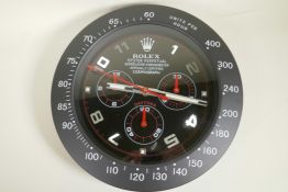 A black cased multi dial wall clock, the dial decorated in the style of Rolex