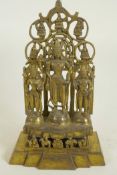 A Chinese gilt bronze figure of three deities standing before a pierced screen decorated with