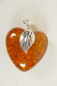 A silver mounted faux amber heart shaped pendant, 1½" long