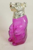 A pale amethyst glass decanter in the form of a bear with silver plated head and glass eyes, 9" high