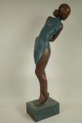 A stylised bronze figurine of a girl in a tight dress, 25½" high