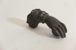 A C19th cast iron door knocker in the form of a hand clutching a fruit