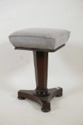 A Victorian mahogany revolving piano stool, raised on a tapering octagonal column and platform