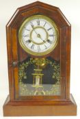 A walnut cased mantel clock with twin train movement striking on a gong, with mercury pendulum,