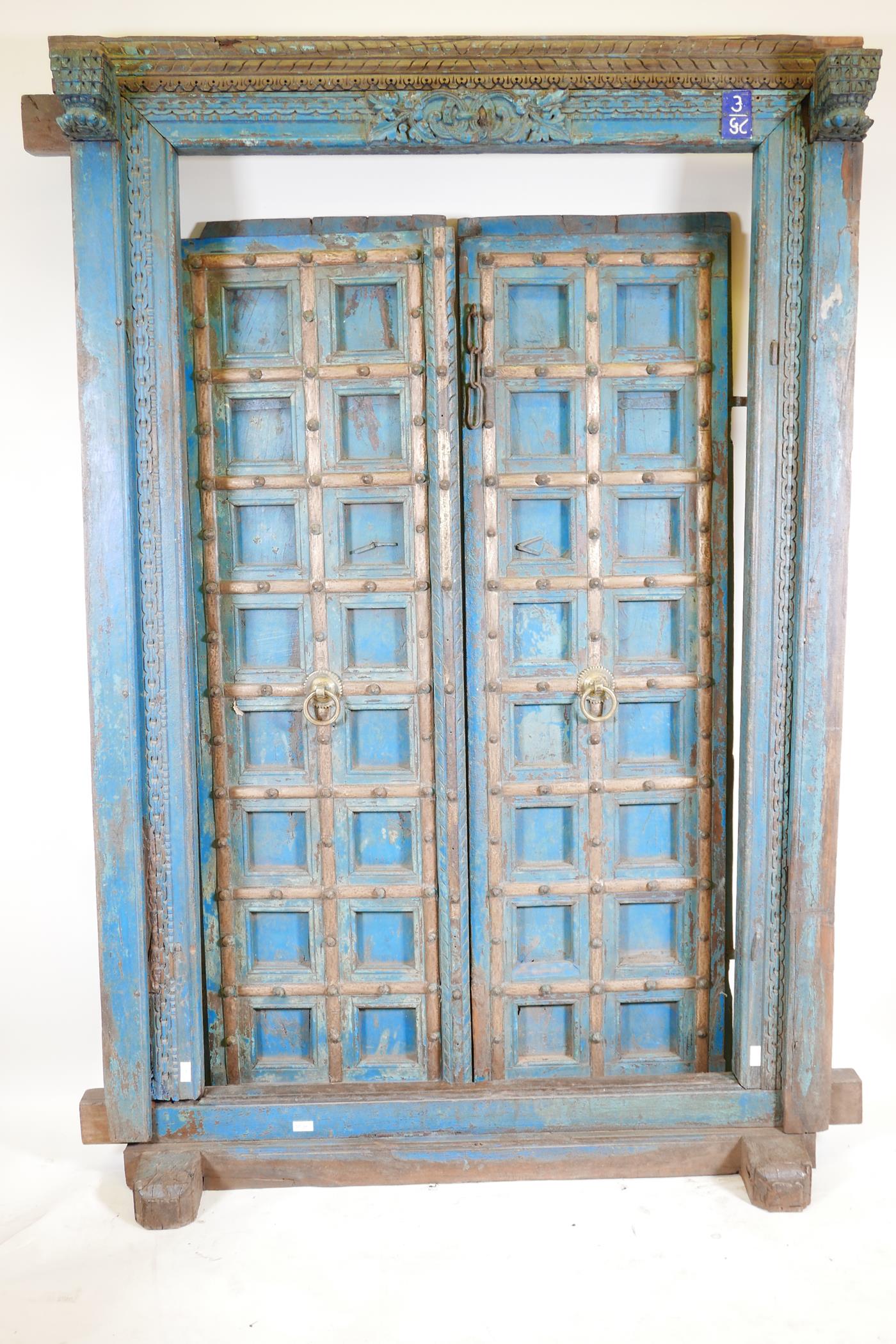 Architectural salvage: A pair of Indian hardwood panelled storm doors, with brass sheathed iron
