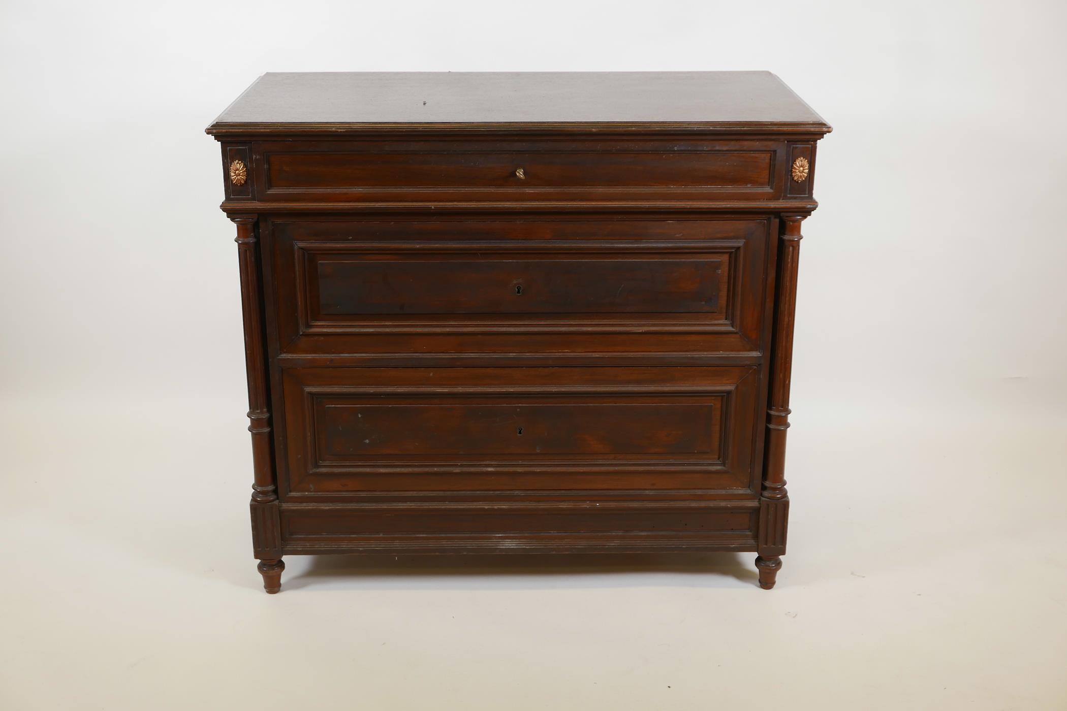 A C19th French mahogany commode with three moulded front drawers flanked by fluted columns, raised