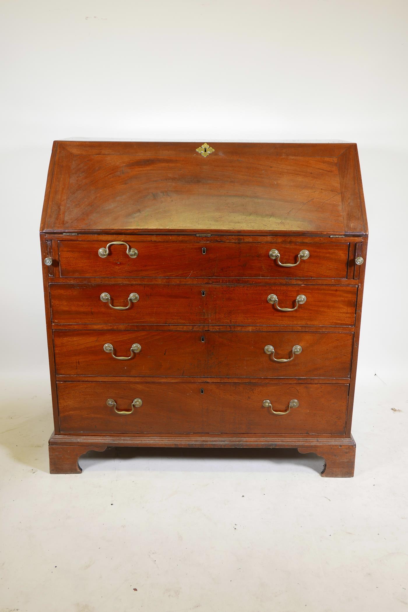 A Georgian mahogany fall front bureau, the fitted interior with secret drawer and slides over four